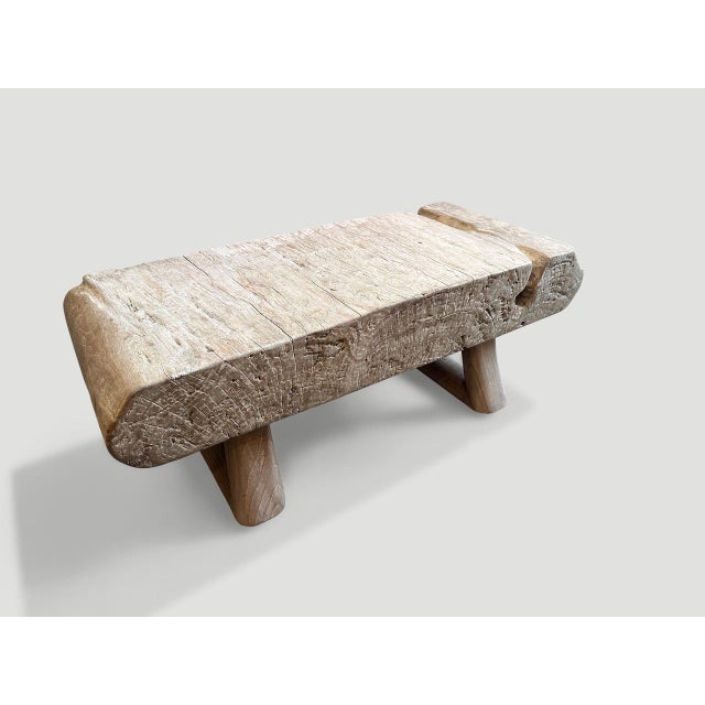 Impressive single six inch slab coffee table or bench made from century old teak wood with a hand carved scroll on one...
