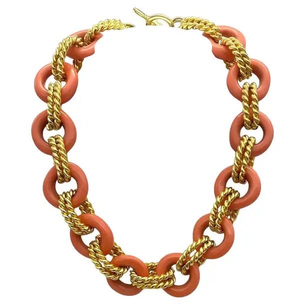 This is a Kenneth Jay Lane vintage coral and gold chunky link necklace. Twelve coral color resin donuts link with double...