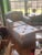 The armchair features a classic blue floral chintz upholstery with a prominent ribbon and bouquet motif, embodying a...