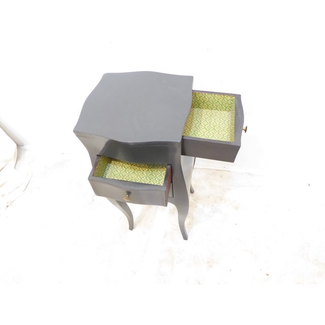 This small bombe shaped side table is painted a laquered charcoal gray.