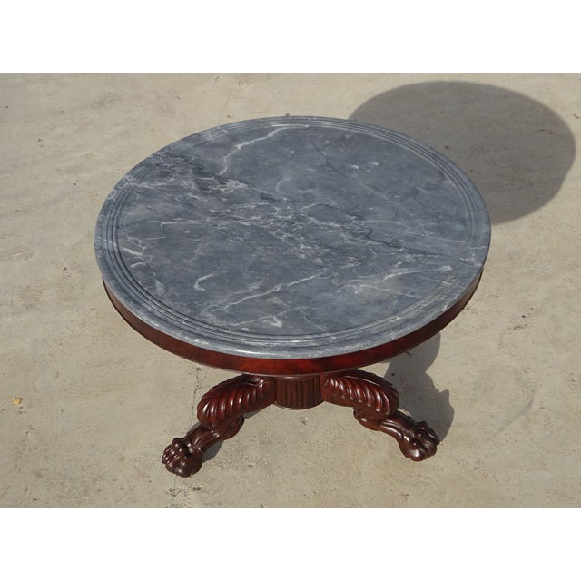 A magnificent small round table from the early 19th century, combining solid mahogany and a beautiful marble top decorated...