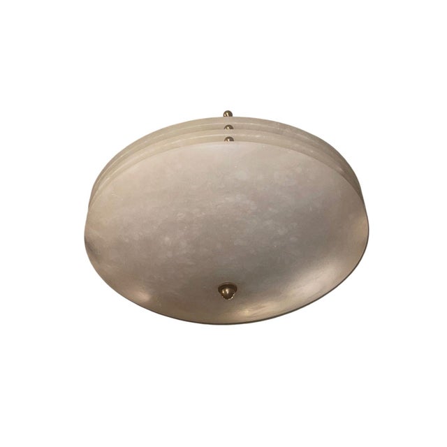 A sophisticated set of three alabaster flush mount ceiling fixtures, dating to the mid-20th century. Each fixture features...