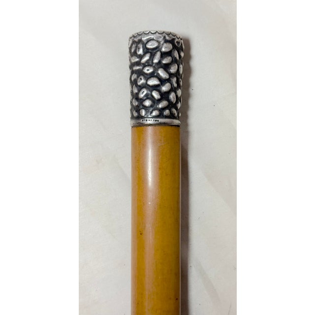 This antique tooled sterling silver and malacca wooden walking stick by Robert Fitz Simmons Company is a unique piece that...