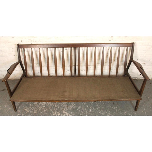 Six foot long three seat sofa with sculpted walnut frame. Featuring a spindle back and angled arms. Tilted back for extra...