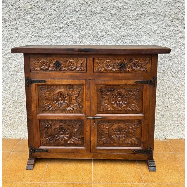 Characterful Spanish cabinet crafted in solid wood, featuring richly carved panels inspired by traditional Castilian...