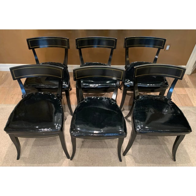 Vintage painted black side chairs with cane seat and loose seat cushion upholstered in polished black vinyl.