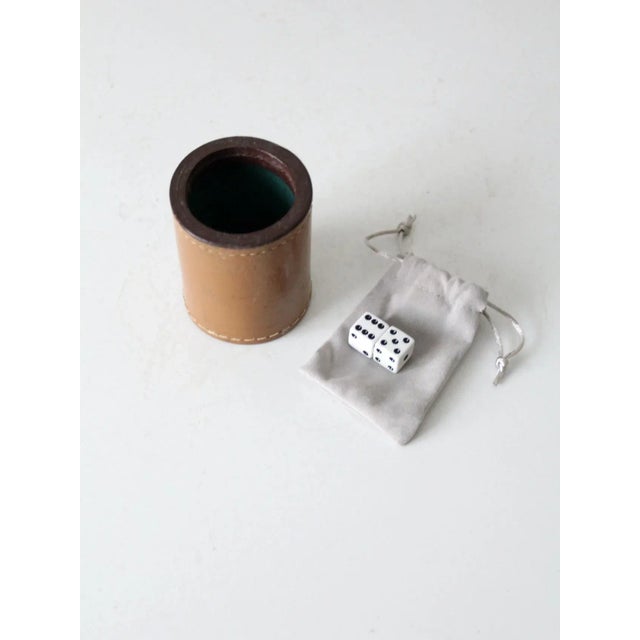 This is a vintage leather dice cup set. It includes a leather dice cup and two dice. MEASUREMENTS Cup: 3.5" H x 2.75" .....