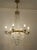 Empire-style chandelier made in Italy in the 1950s–1960s, featuring a brass frame enriched with cut crystals, illuminated...