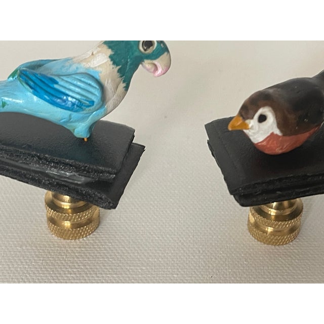 Cute pair of handmade small bird figurines mounted on brass bases as lamp finials.