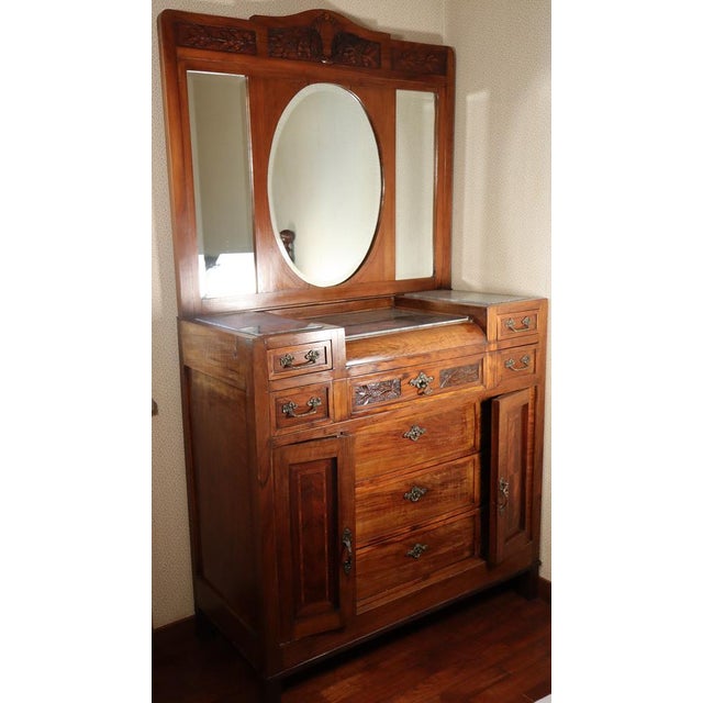 This pure Art Nouveau chest of drawers was crafted from solid wood in the early 1900s. It features a two-tiered base with...