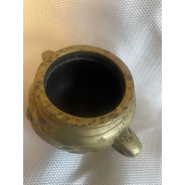 This 19th-century Chinese tripod censer is a beautiful example of late Qing Dynasty metalwork. Cast in solid bronze, the...