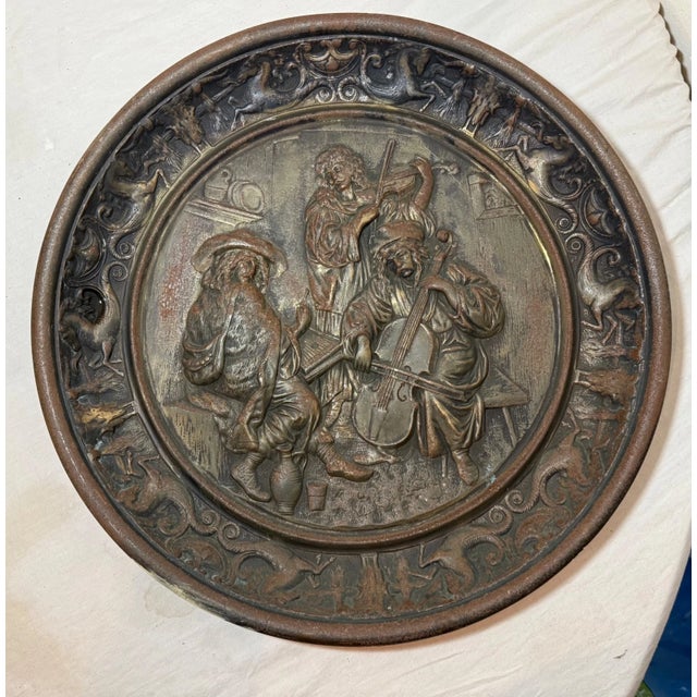 The large antique ornate bronze patinated cast iron relief wall plaque featuring a figural design in high relief is a...