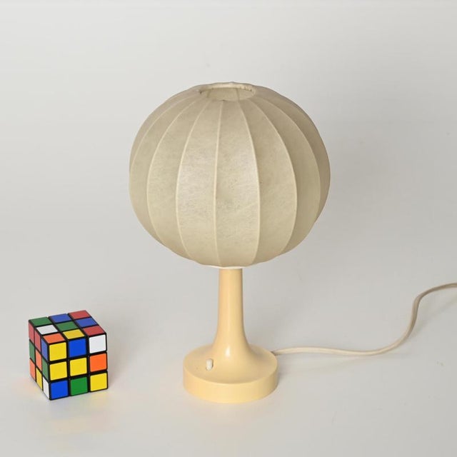Delightful mid-century cocoon table lamp with a cream colored plastic base. This incredibly sylish and unique table lamp...