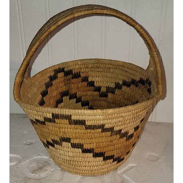 This hand woven basket with a handle is in fine condition and has a wonderful geometric pattern. circa 1940s