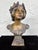 This finely modeled Art Nouveau bust titled “Enid” depicts a serene young woman crowned with a laurel wreath, a classical...