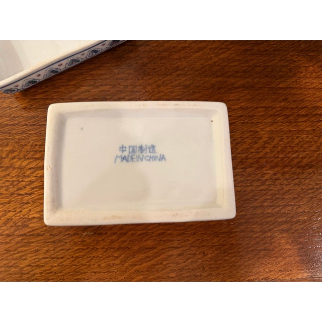 A small vintage Chinoiserie porcelain box with lid, hand-painted in classic blue and white with a soft pink lotus flower...