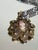 Vintage mid-century cameo pendant necklace featuring a central oval cameo in a filigree-style openwork setting with floral...