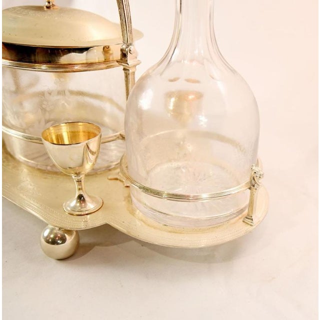 Elegant silver plated tantalus set of refined traditional design Comprising two glass decanters with faceted stoppers...