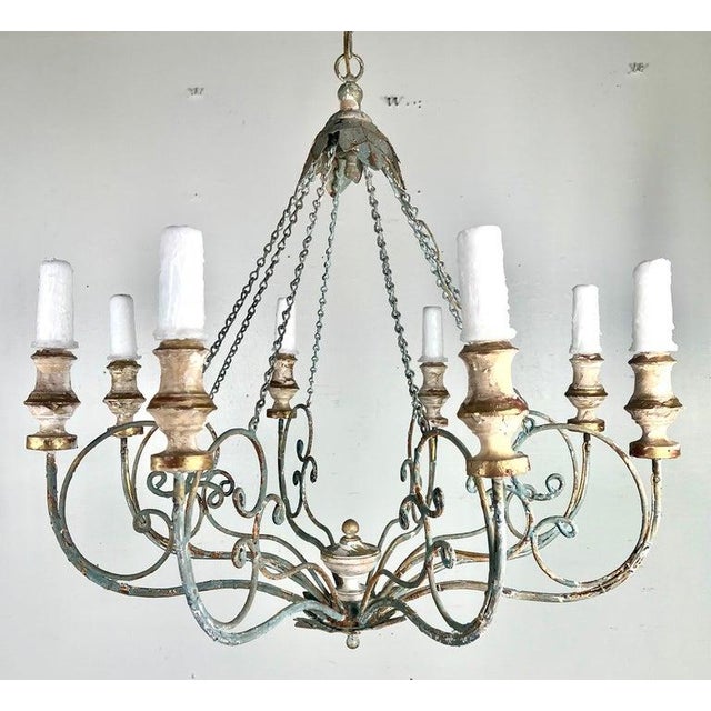 Eight arm painted iron & wood Melissa Levinson chandelier. The iron is beautifully scrolled with wood painted bobeches....