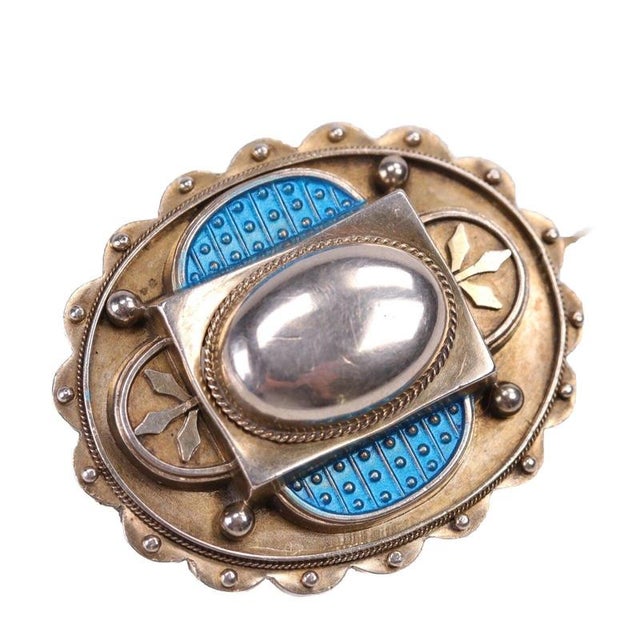 A polished oval silver boss set within a rope-twist border forms the raised centre of this multi-tiered brooch. Flanking...