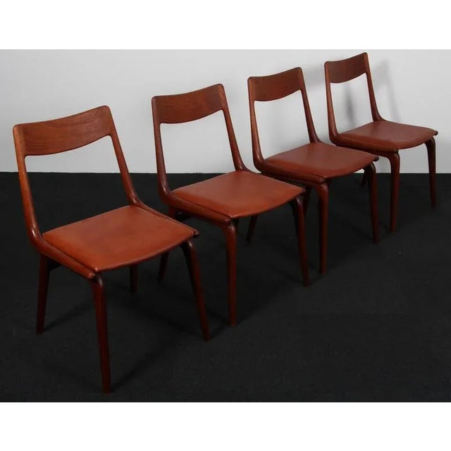 Alfred Christensen dining chairs in teak, new upholstered with cognac smooth aniline leather. Model Boomerang, made by...