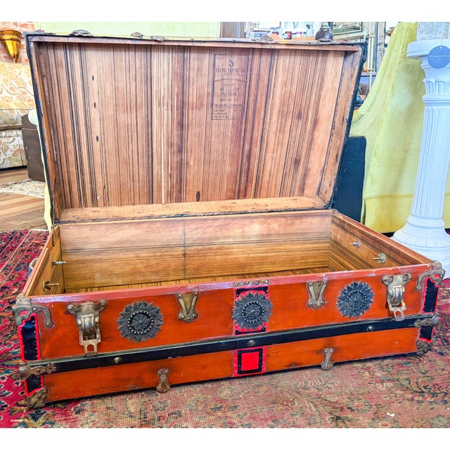 Brick red Antique trunk lined with cedar, straps across top and side, leather side handles, medallion style accents and...