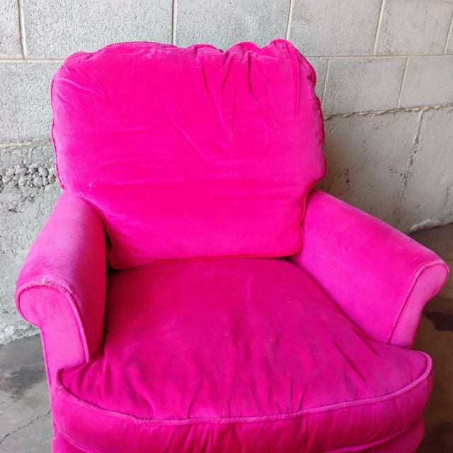 A vibrant pink velvet armchair and ottoman set, embodying Hollywood Regency glamour. The ruffle skirt and plush cushioning...