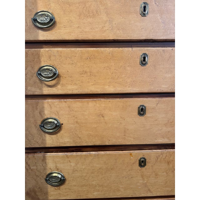 This is an antique chest of drawers. It is American. It is tiger maple wood. There are six drawers for storage. It has a...