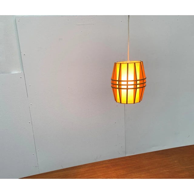 Mid-century wooden pendulum. The lamp body forms a finely executed rib structure, which is covered from the inside with a...