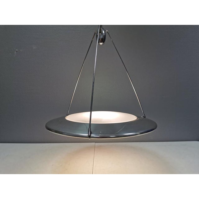 Postmodern ufo or flying saucer hanging lamp that gives diffused light upwards and downwards. A real eye-catcher even...