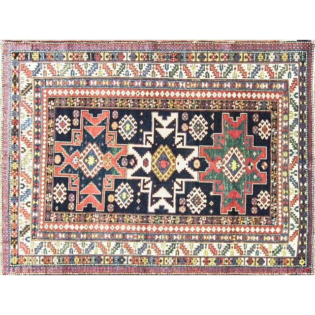 This beautiful antique Caucasian Lesghi rug features a striking deep blue field accented by rich green, soft ivory, and...