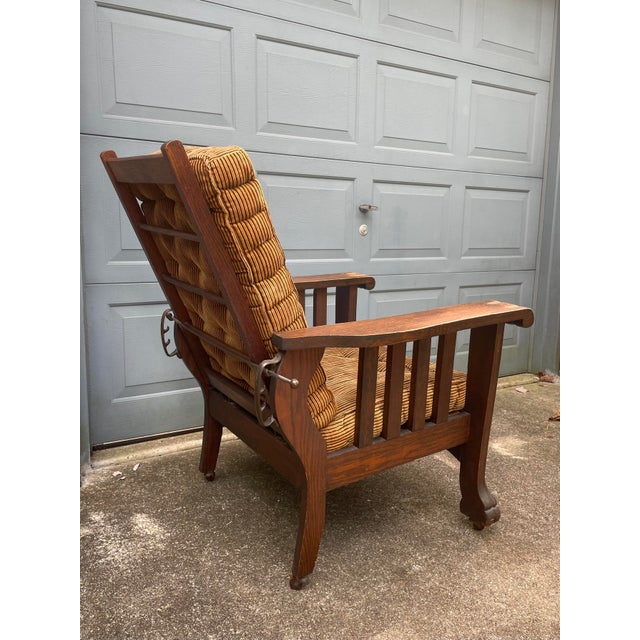 A late 1800s quarter sawn oak Morris recliner with a striking and unique paw arm and claw foot design. A nicely patinated...