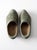 This pair of early 20th century antique wooden clogs features softly worn green paint with hand-applied speckled detailing...