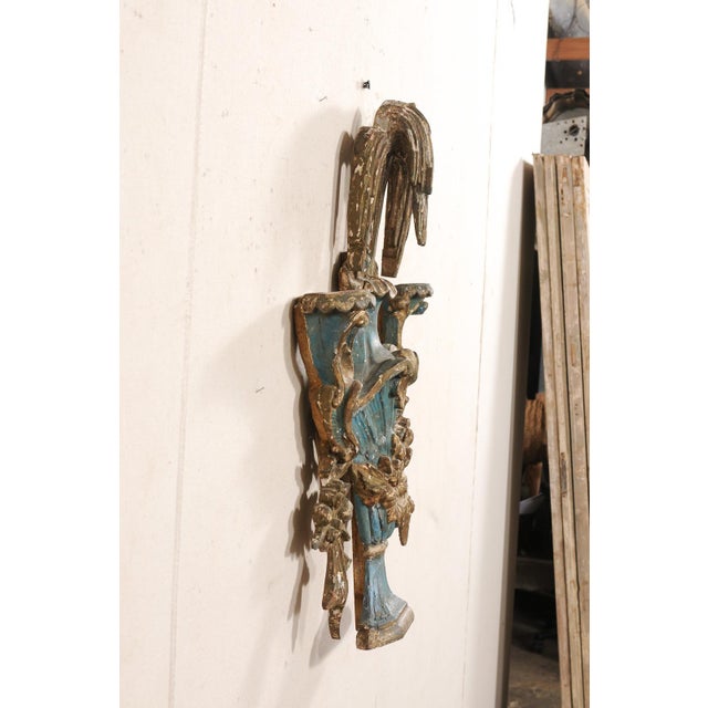 An Italian carved and painted wood urn fragment from the 18th century. This antique wall decoration from Italy has been...