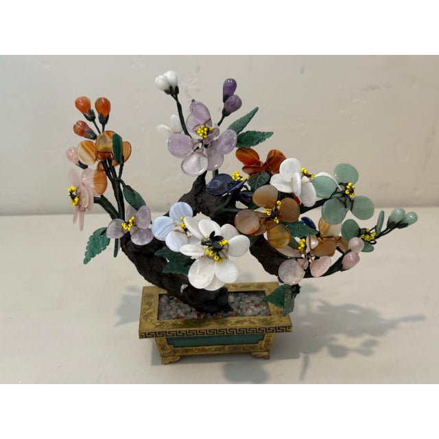 Mid Century carved multi semi precious stones Bonsai flower tree in a brass pot inlaid with dark green jade panels. The...
