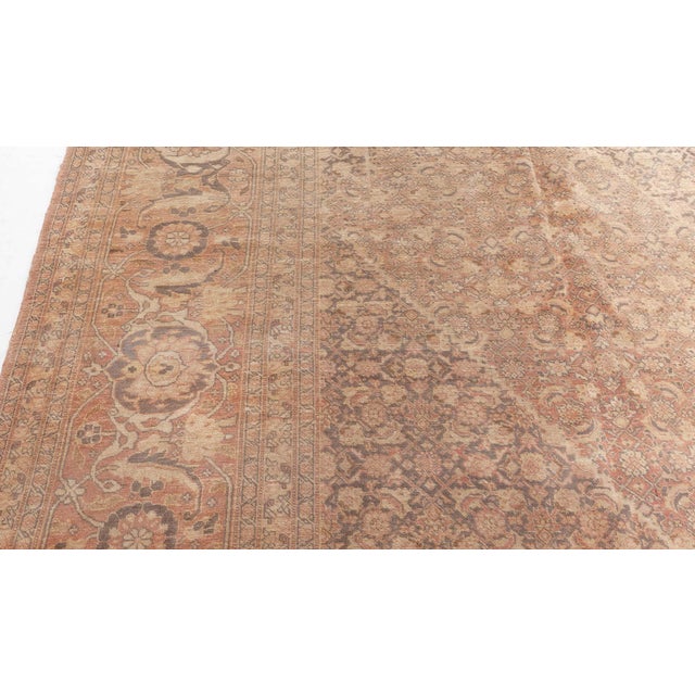 A Tabriz carpet from Northwest Persia, having a dense herati pattern in beige around a medallion containing a stepped...