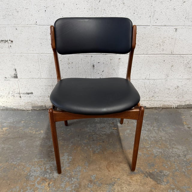 A Danish teak Model 49 dining chair by Erik Buch, dating to the 1960s. The chair has a sculpted teak frame with rounded...