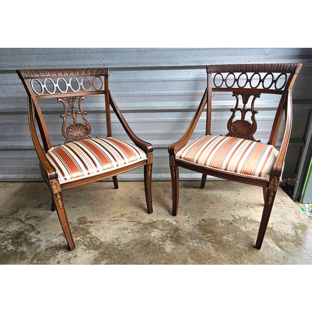 A Pair of English Regency mahogany frame dining chairs, early 19th century. Features exquisite carved back-splats in...