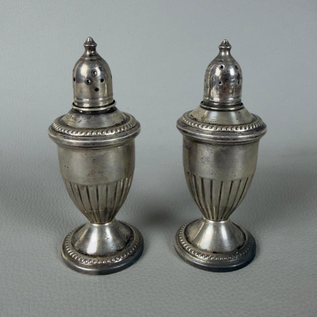 A refined pair of vintage amphora-shaped salt and pepper shakers, original with sterling weighted hallmarks from the early...