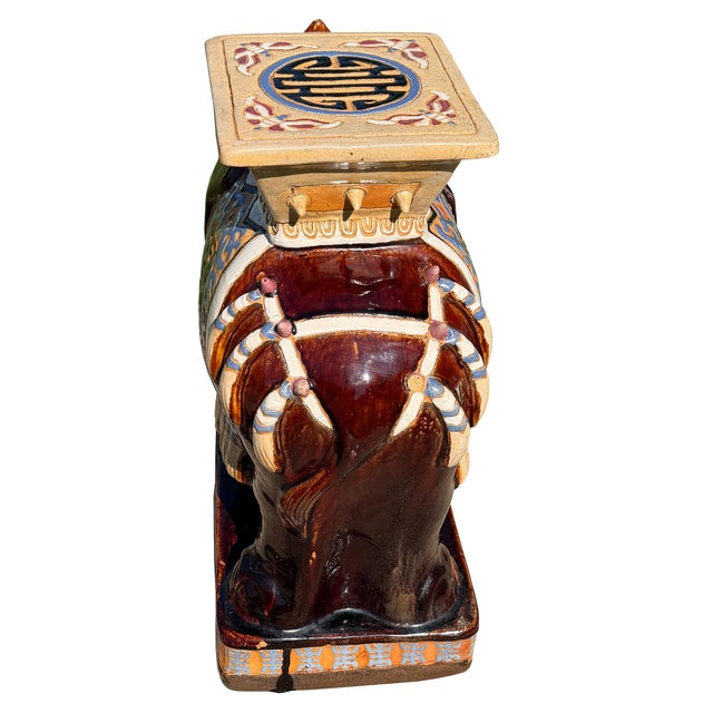 A striking and highly decorative vintage Asian ceramic elephant garden seat or plant stand, rendered in a rich oxblood...