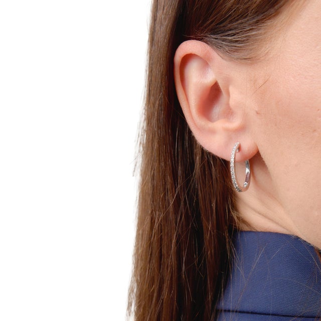 These classic vintage hoop earrings showcase a graceful row of round brilliant diamonds, offering a soft and consistent...