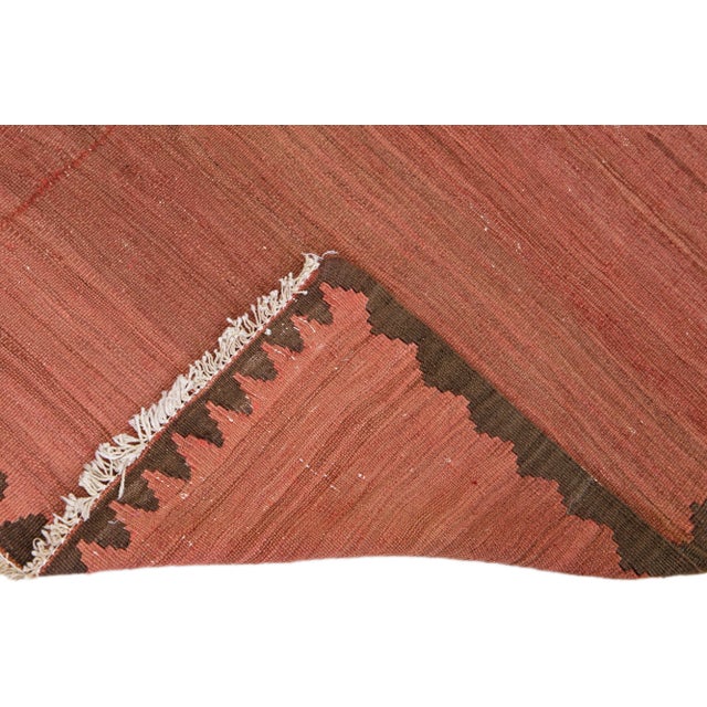 Beautiful vintage Turkish Kilim hand-knotted wool rug with a rust field. This piece has brown accents in an all-over...