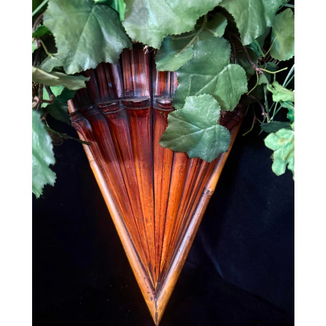 This pair of wall mounted planters feature a distinct triangular shape constructed from slatted bamboo, designed to mimic...