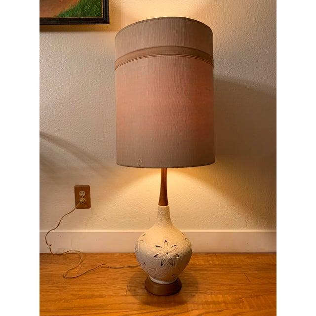 Beautiful teak and ceramic table lamp without the shade. This shapely fixture has a long teak neck and a cream bulb shape...