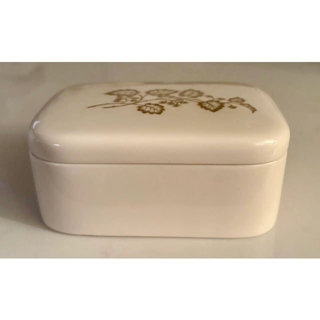 Add a little glamour to your decor with this ivory porcelain cigarette or jewelry box with gold detailing. Part of the...