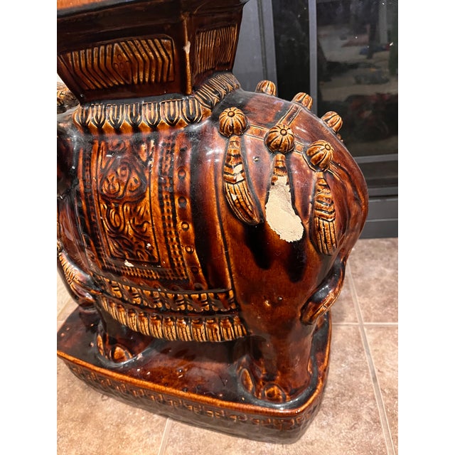A striking vintage glazed ceramic elephant garden stool or side table, featuring intricate sculptural detailing and a rich...