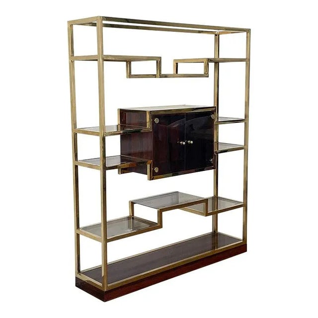 Gilt brass tubular bookcase with base and display case inserted into the central makassar compartment. The shelves and two...