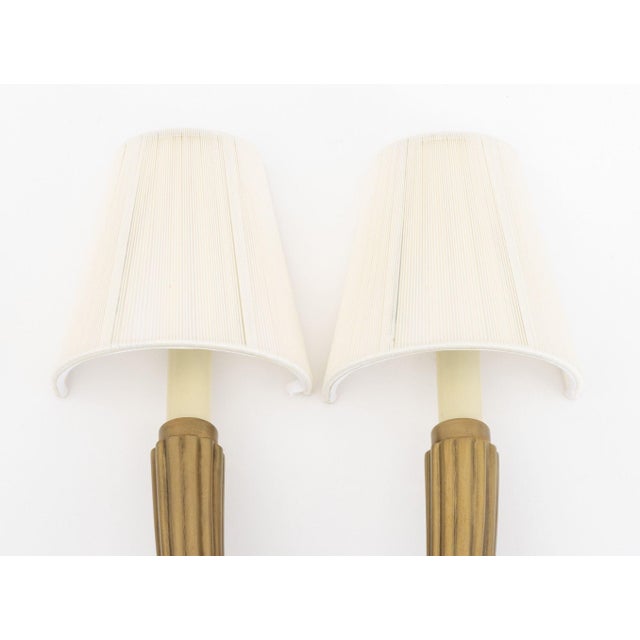 Pair of Art Deco Style Brass Two-Branch Wall Sconces, each with two fluted arms with candlestick style lights and cloth...