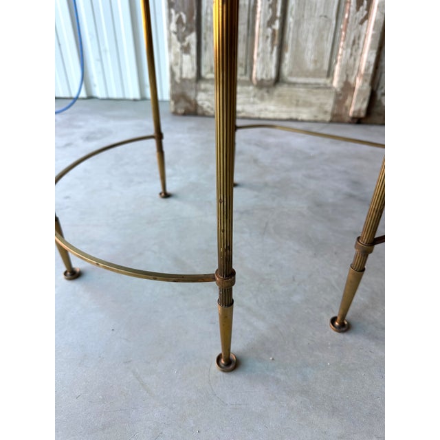 An elegant bronze and gilt brass coffee table attributed to maison baguès. It features a refined structure composed of...