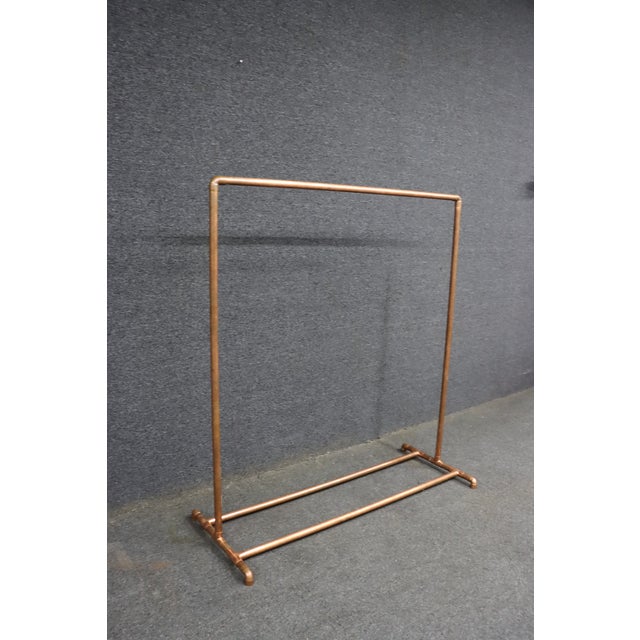 Industrial-style freestanding garment rack constructed from copper plumbing pipe with a warm natural patina. Featuring a...
